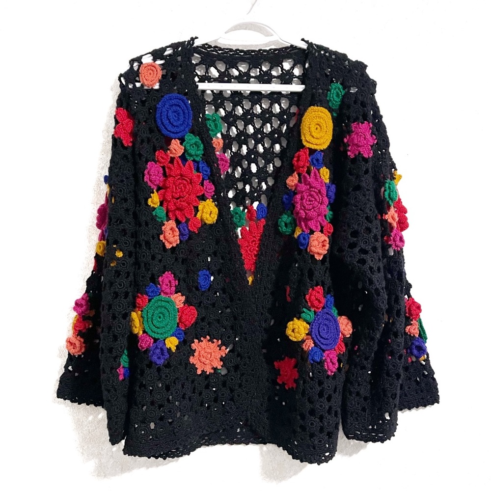 Crocheted open front cardigan with 3 dimensional flowers.